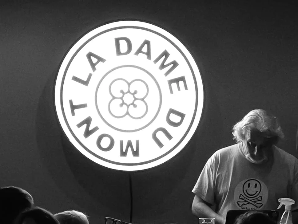 Bob prépare ses extraits devant le logo de La Dame du Mont